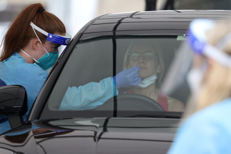 FILE PHOTO: A medical worker swabs a member of the public at a drive-through COVID-19 testing centre in Sydney