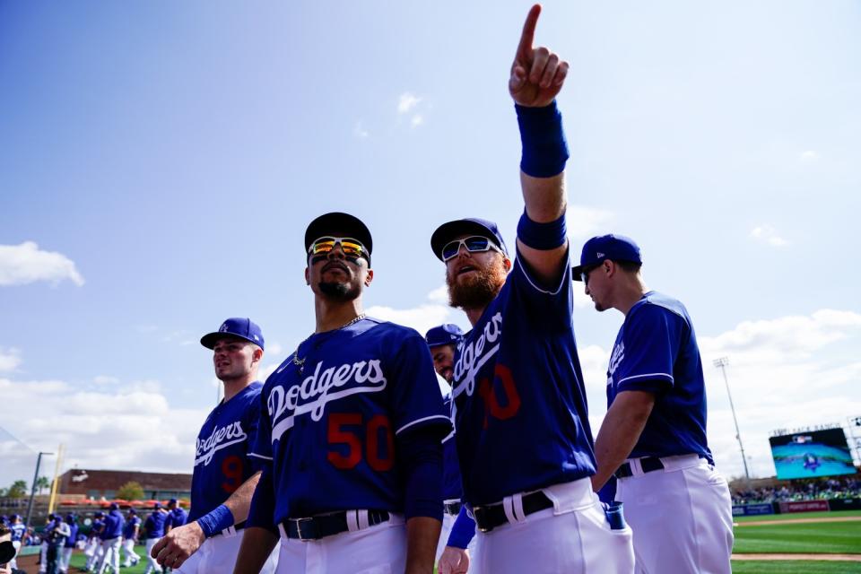 Dodgers right fielder Mookie Betts, left, and third baseman Justin Turner, right, on the field.