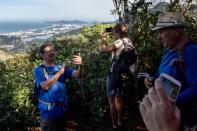 People take photos as they hike a trail above Rio de Janeiro, soon to be part of a countrywide network of hiking paths