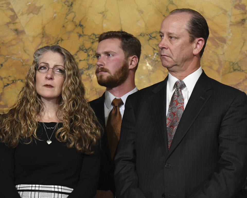 Evelyn Piazza, left, and Jim Piazza, right, listen during a news conference in the Pennsylvania governor's office, Friday, Oct. 19, 2018 in Harrisburg, Pa., on anti-hazing legislation inspired by their son, Penn State student Tim Piazza, who died after a night of drinking in a fraternity house early last year. Standing between them is Tim Piazza's brother, Mike Piazza. (AP Photo/Marc Levy)