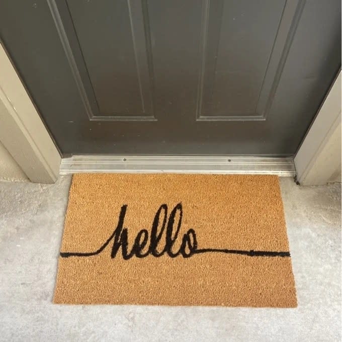 The door mat reading "hello" in front of the front door 