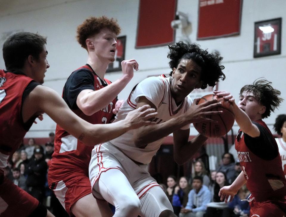 Cranston West forward Kennedy Arias gets swarmed by Coventry's Logan Moore, Logan Voelker, and Caleb Whited, from left, on his way to the Falcon net in the first half.