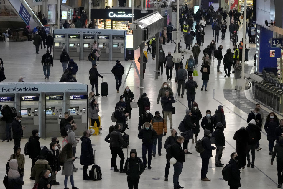 People pass through Waterloo train station, in London, during the morning rush hour, Monday, Nov. 29, 2021. The new potentially more contagious omicron variant of the coronavirus popped up in more European countries on Saturday, just days after being identified in South Africa, leaving governments around the world scrambling to stop the spread. In Britain, Prime Minister Boris Johnson said mask-wearing in shops and on public transport will be required, starting Tuesday. (AP Photo/Matt Dunham)