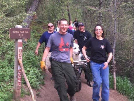 Kato, the 120-pound dog who needed to be rescued, looks like royalty as the humans carry him down. It is something he could grow accustomed to. (Photo: Facebook)