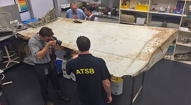 Australian Transport Safety Bureau (ATSB), staff examine a piece of aircraft debris at their laboratory in Canberra found off Tanzania last year. Photo: AAP