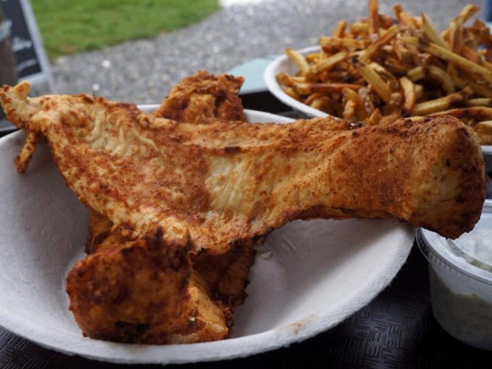 Fried fish in a bowl next to a bowl of fried chips.