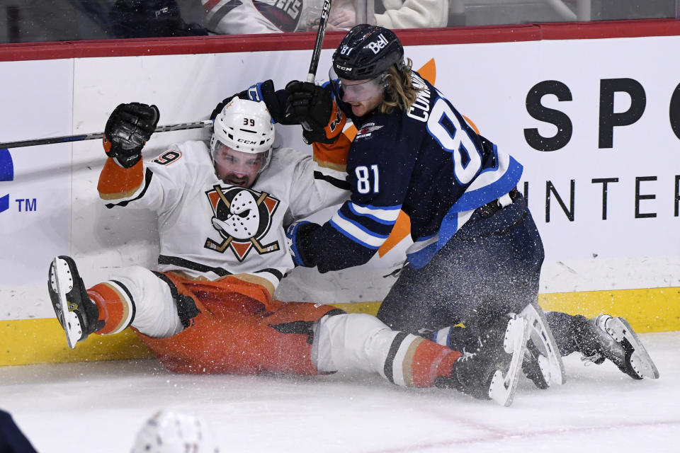 Anaheim Ducks' Sam Carrick (39) collides with Winnipeg Jets' Kyle Connor (81) during the third period of an NHL Hockey game in Winnipeg, Manitoba on Sunday, Dec. 4, 2022. (Fred Greenslade/The Canadian Press via AP)