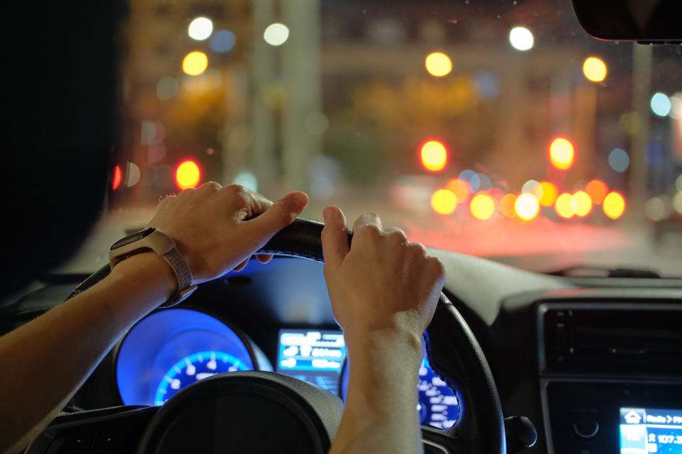 close up of hands on a steering wheel