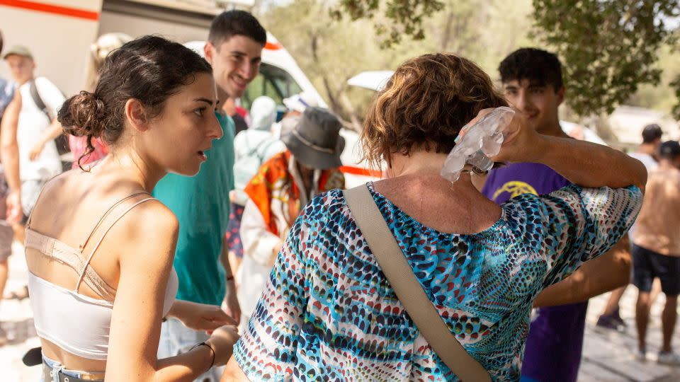 Ένας τουρίστας δροσίζεται με παγάκια στην είσοδο της Ακρόπολης στο κέντρο της Αθήνας.  - Σωκράτης Μπαλταγιάννης/Image Alliance/Getty Images