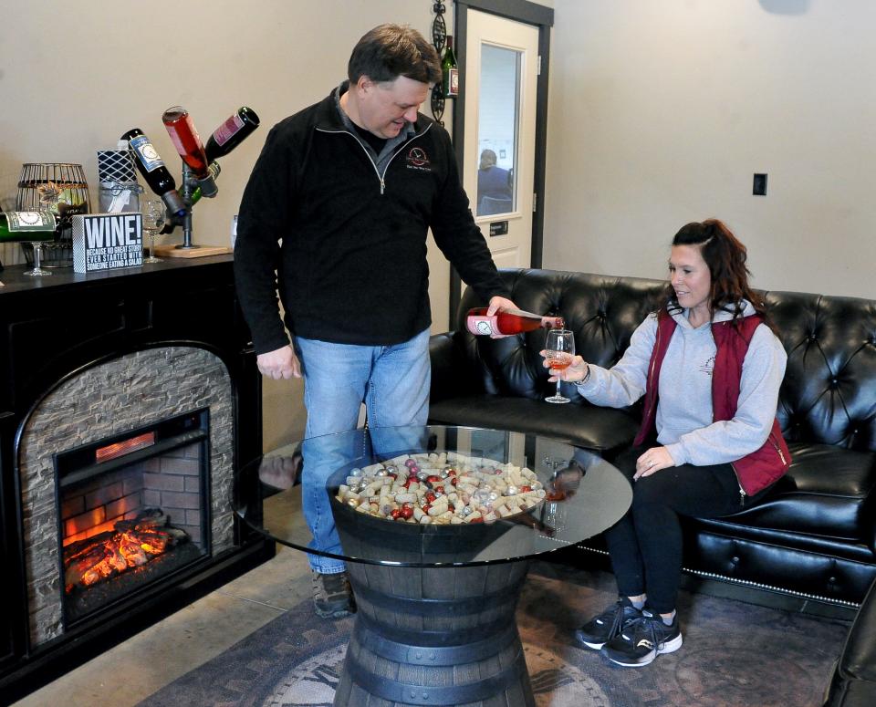 Jim Borton (left) pours a glass of wine for Trisha Maibach in the lounge area at Lincoln Way Vineyards. The winery will host a special Valentine's Dinner Saturday featuring five courses and live music.