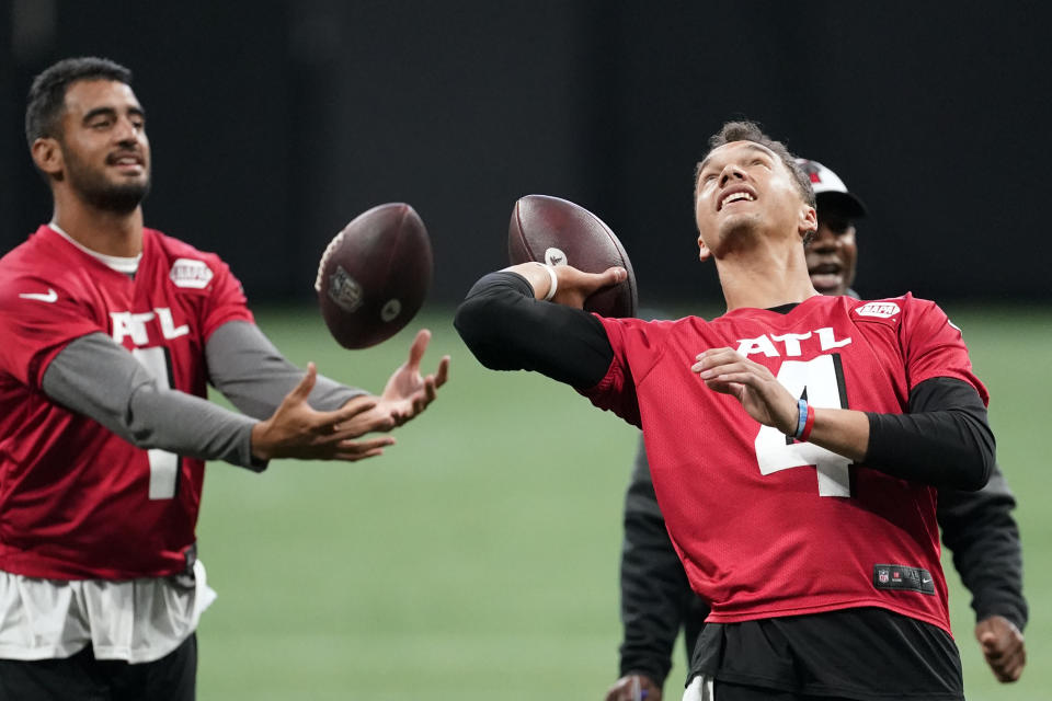 Atlanta Falcons quarterbacks Desmond Ridder (4) and Marcus Mariota (1) are shown during a voluntary offseason NFL football practice to begin Friday, June 3, 2022, in Atlanta. (AP Photo/John Bazemore)