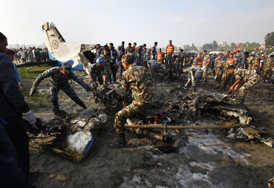 Nepalese police salvage debris at the crash site of a Sita Air airplane near Katmandu, Nepal, early Friday, Sept. 28, 2012.  The plane carrying trekkers into the Everest region crashed just after takeoff Friday morning in Nepal's capital, killing all 19 people on board, authorities said. (AP Photo/Niranjan Shrestha)