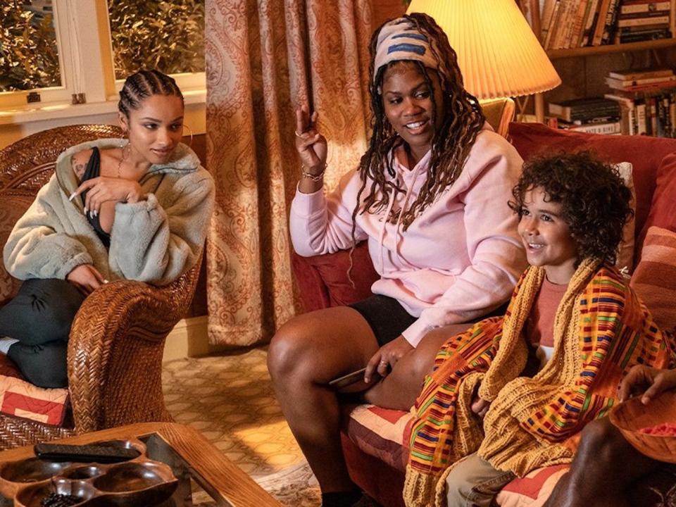 Two women and a man sit around a young boy in a living room.