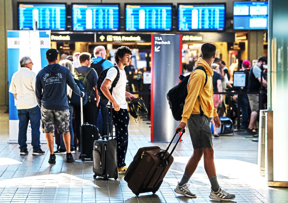 Passengers pass a security line Thursday, June 30, 2022, at the Pittsburgh International Airport in Moon Township, Pa. The airport saw an influx of travelers departing Pittsburgh before the Fourth of July holiday weekend. (Morgan Timms/Pittsburgh Post-Gazette via AP)