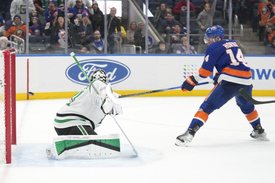 New York Islanders center Bo Horvat (14) scores the winning goal past Dallas Stars goaltender Scott Wedgewood, left, during overtime of an NHL hockey game Sunday, Jan. 21, 2024, in Elmont, N.Y. (AP Photo/Mary Altaffer)