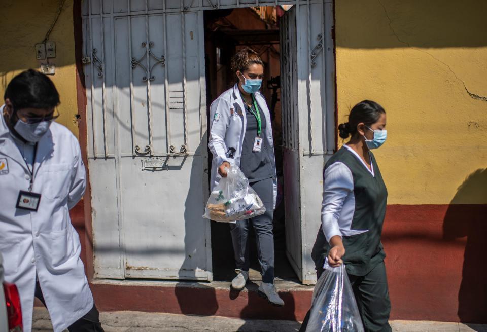 A health brigade leaves a house while on door-to-door visits to carry out COVID-19 tests in Mexico City, on June 16, 2020, amid the new coronavirus pandemic. (Photo by PEDRO PARDO / AFP) (Photo by PEDRO PARDO/AFP via Getty Images)