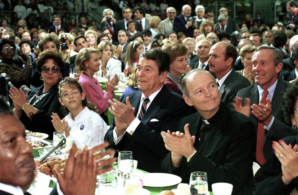 FILE - In this Oct. 12, 1988 file photo, President Ronald Reagan, center, and Newark Archbishop Theodore McCarrick, right, attend a Republican party campaign stop in West Orange, N.J. On Tuesday, Nov. 10, 2020, the Vatican is taking the extraordinary step of publishing its two-year investigation into the disgraced ex-Cardinal McCarrick, who was defrocked in 2019 after the Vatican determined that years of rumors that he was a sexual predator were true. (AP Photo/Barry Thumma)