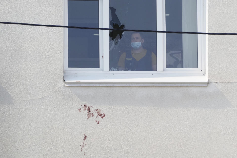 A police investigator looks at a window with a bullet hole in the school No.175 in Kazan, Russia, Wednesday, May 12, 2021, after a shooting on Tuesday. Russian officials say a gunman attacked a school in the city of Kazan and Russian officials say several people have been killed. Officials said the dead in Tuesday's shooting include students, a teacher and a school worker. Authorities also say over 20 others have been hospitalised with wounds. (AP Photo/Dmitri Lovetsky)