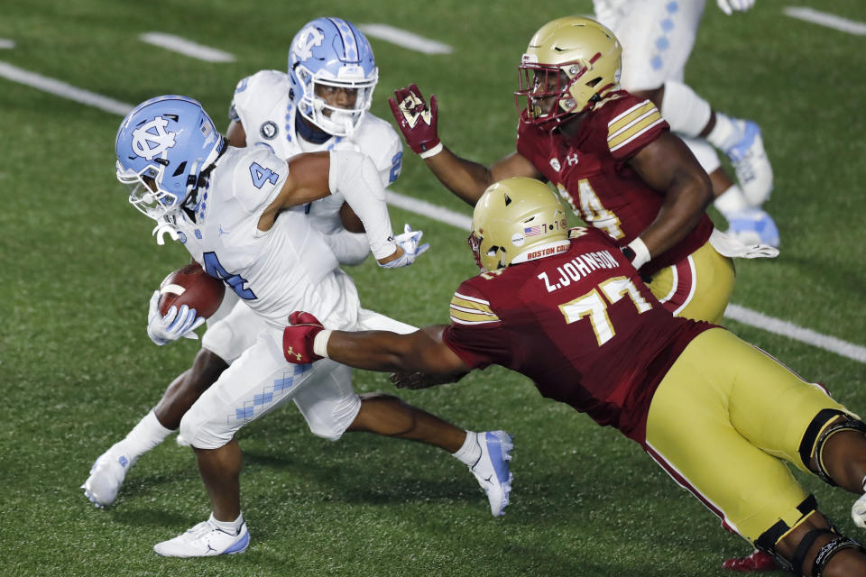 North Carolina defensive back Trey Morrison (4) evades Boston College offensive lineman Zion Johnson (77) after intercepting a two-point conversion attempt during the second half of an NCAA college football game, Saturday, Oct. 3, 2020, in Boston. (AP Photo/Michael Dwyer)