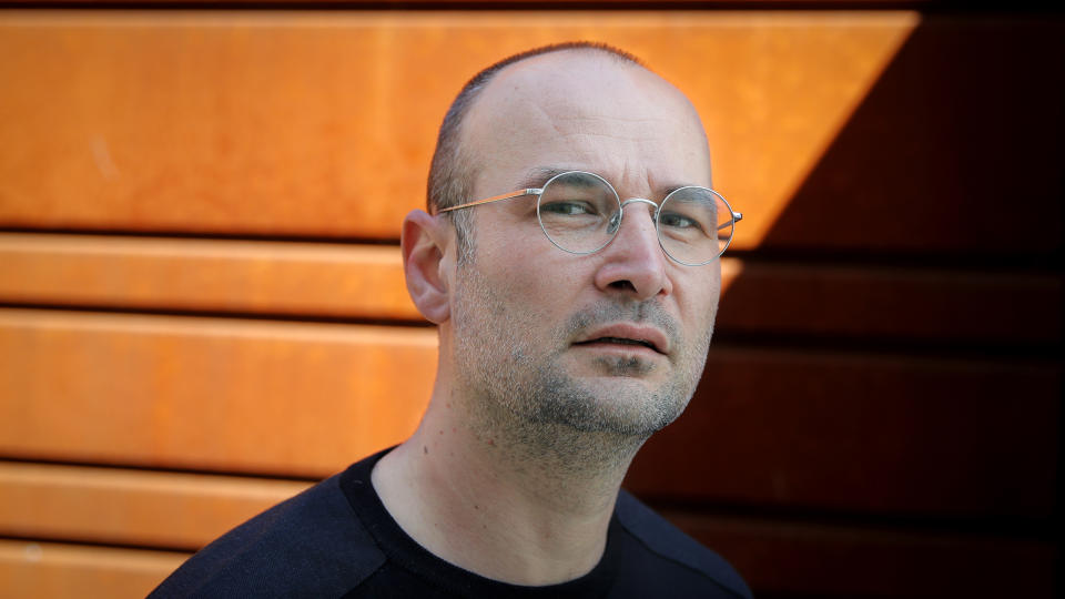 Romanian director Alexander Nanau, poses for a photograph outside the Elvire Popesco cinema in Bucharest, Romania, Monday, April 12, 2021. The Oscar-nominated Romanian documentary film “Collective” follows a group of journalists delving into the state of health care in the eastern European country in the wake of a deadly 2015 nightclub fire that left dozens of burned victims in need of complex treatment. What they revealed was decades of deep-rooted corruption, a heavily politicized system scarily lacking in care. (AP Photo/Vadim Ghirda)