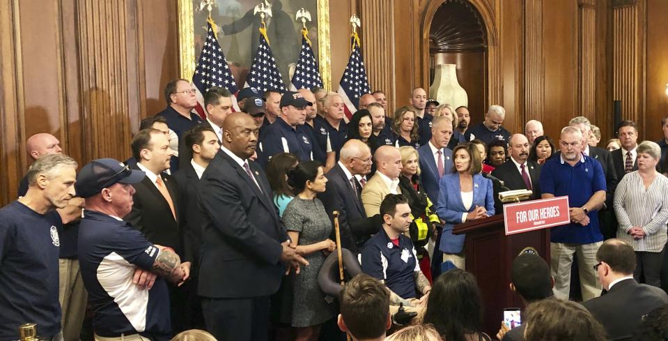 House Speaker Nancy Pelosi speaks at a news conference on behalf of 9/11 victims and families, Friday, July 12, 2019, at the Capitol in Washington. The House is expected to approve a bill Friday ensuring that a victims' compensation fund for the Sept. 11 attacks never runs out of money. Entertainer and activist Jon Stewart, listens at left. (AP Photo/Matthew Daly)