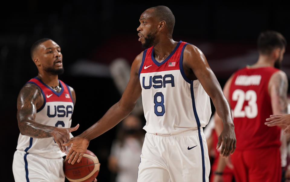 United States' Damian Lillard (6), left, and Khris Middleton (8) celebrate at the end of first quarter during men's basketball preliminary round game against Iran at the 2020 Summer Olympics, Wednesday, July 28, 2021, in Saitama, Japan. (AP Photo/Charlie Neibergall)