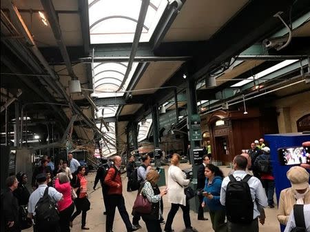 Onlookers view a New Jersey Transit train that derailed and crashed through the station in Hoboken, New Jersey. Courtesy of David Richman via REUTERS