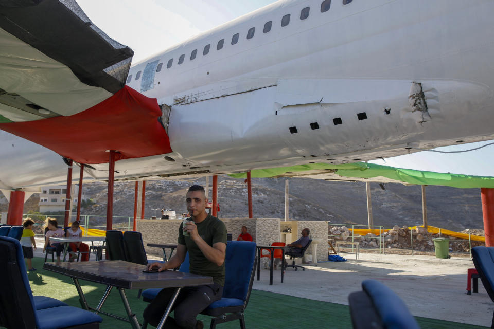 Palestinians visit a Boeing 707 aircraft after it was converted to a cafe restaurant, in Wadi Al-Badhan, near the West Bank city of Nablus, Wednesday, Aug. 11, 2021. The Palestinian territory has no civilian airport and those who can afford a plane ticket must catch their flights in neighboring Jordan. After a quarter century of effort, twins brothers, Khamis al-Sairafi and Ata, opened the “Palestinian-Jordanian Airline Restaurant and Coffee Shop al-Sairafi” on July 21, 2021, offering people an old airplane for customers to board. (AP Photo/Majdi Mohammed)