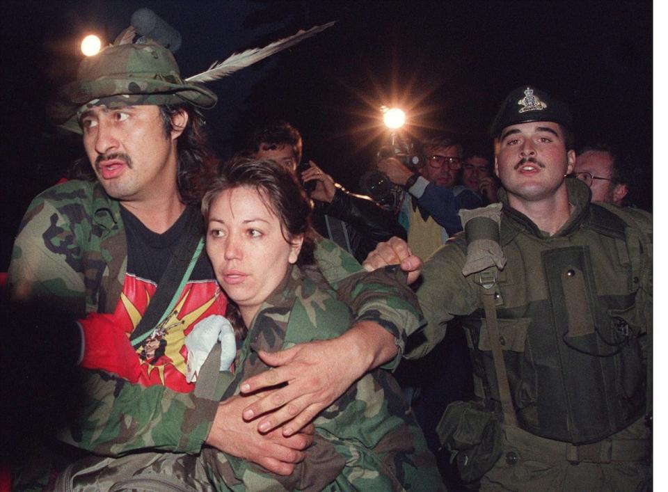 Sept. 26, 1990: Mohawk Warrior known as Noreiga clutches a Mohawk woman as he is taken into custody Sept. 26, 1990 by Canadian soldiers during the surrender at the Kanasehtake Reserve at Oka.