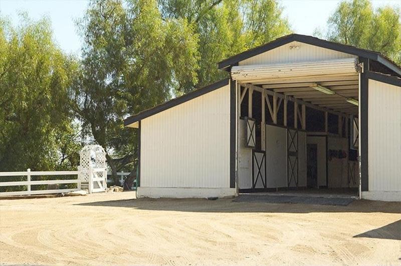 <p>Separate barns and stables fit six horses, who are free to roam in the equestrian ring, the one-acre riding area or either of the two paddocks.</p>