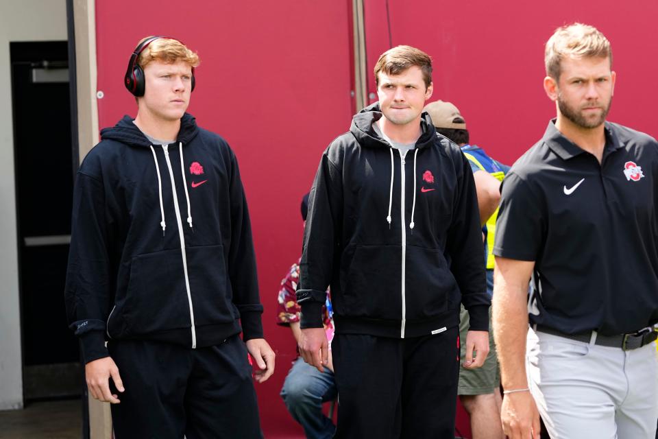 Ohio State quarterbacks Devin Brown, left, and Kyle McCord walk onto the field after arriving at Indiana.