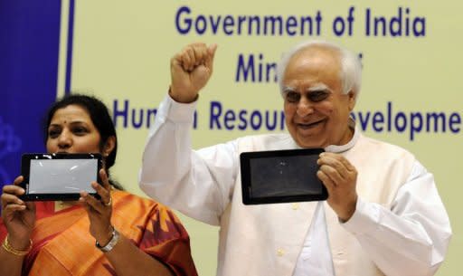 Indian Human Resource Develpoment (HRD) Minister Kapil Sibal (R) and Junior HRD Minister D. Purandeswari (L) pose with "Akash" the 46 USD (34 euros) tablet after its launch in New Delhi. India launched its long-awaited "computer for the masses", unveiling a 46 USD tablet device designed to bring the information technology revolution to tens of millions of students