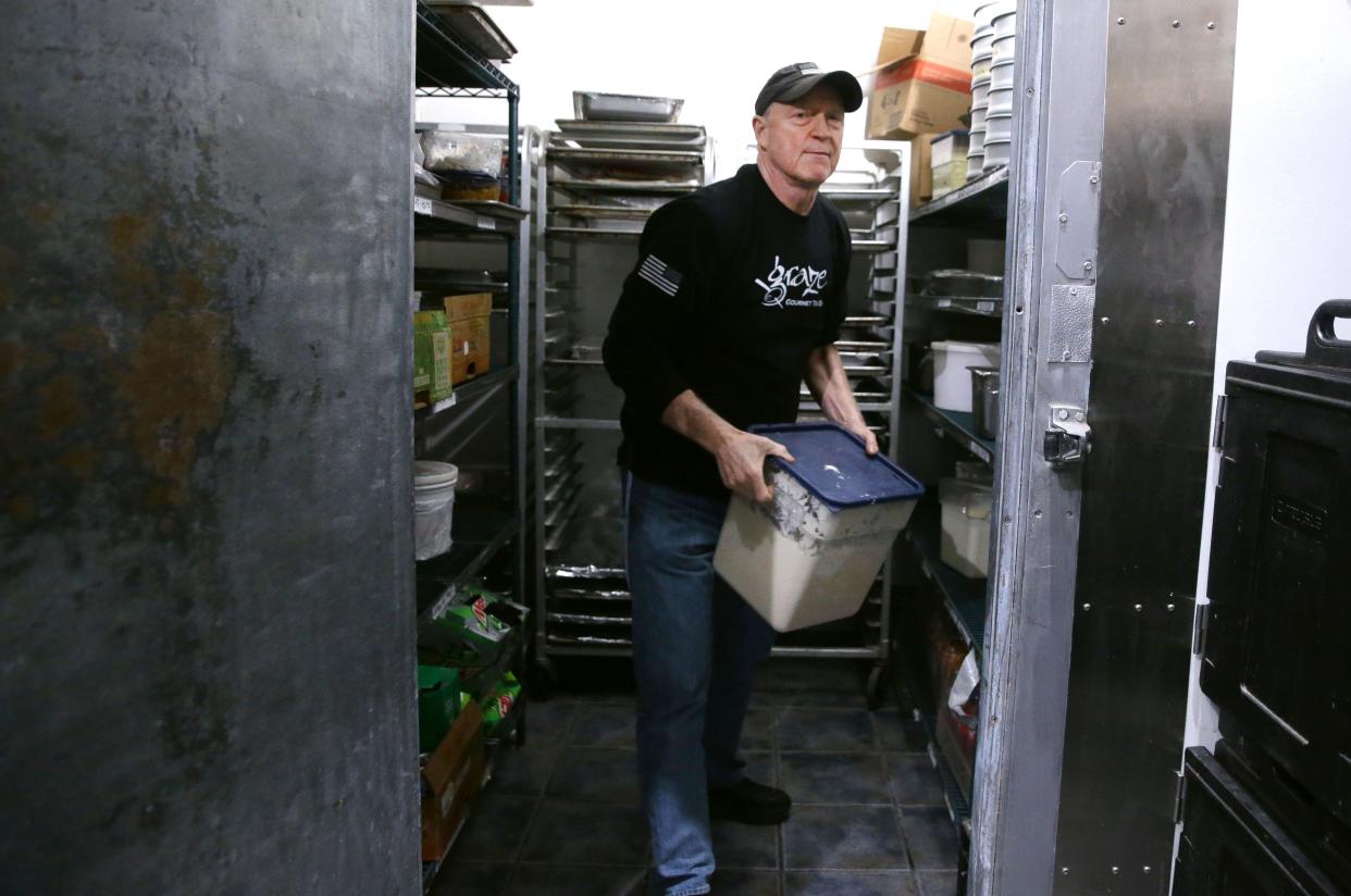 Graze Gourmet To Go’s owner Peter Harman pulls the pizza dough starter out of the walk-in cooler Tuesday, March 26, 2024 at the restaurant in Iowa City, Iowa.