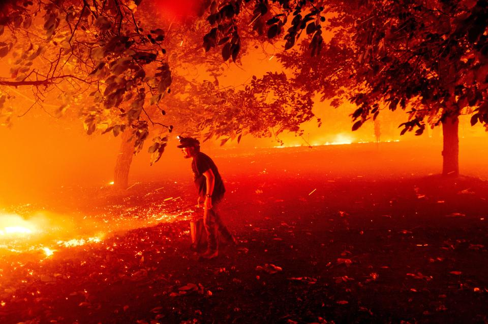Matt Nichols tries to save his home as the LNU Lightning Complex fires tear through Vacaville, Calif., on Wednesday, Aug. 19, 2020. Fire crews across the region scrambled to contain dozens of wildfires sparked by lightning strikes as a statewide heat wave continues.