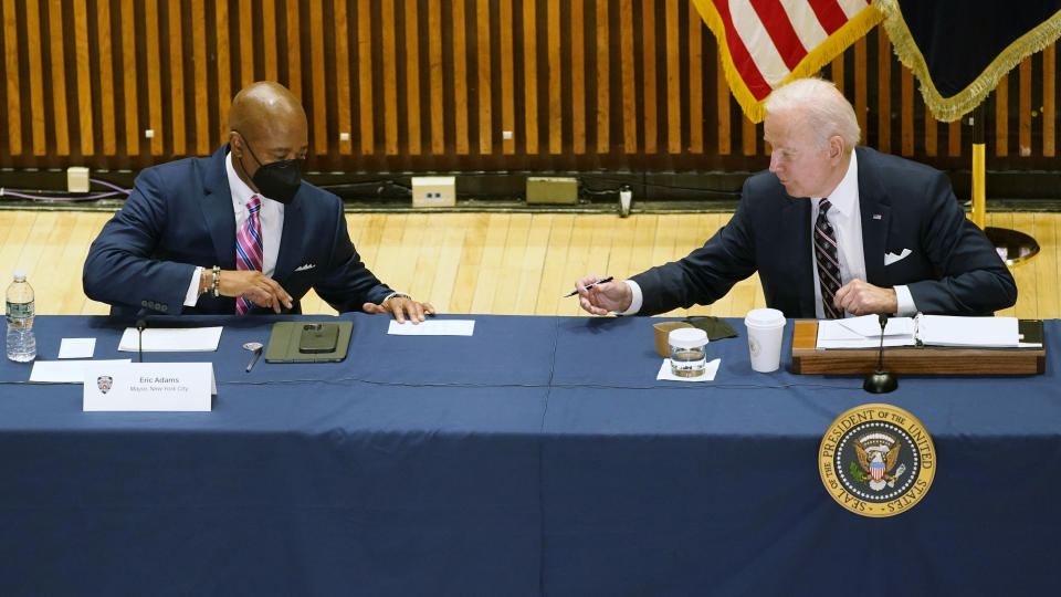 President Joe Biden hands a note to New York City Mayor Eric Adams during a discussion on gun violence strategies, at police headquarters, Thursday, Feb. 3, 2022, in New York. (AP Photo/Alex Brandon)