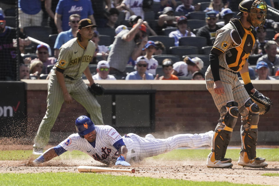 New York Mets Eduardo Escobar slides homer a score in the 6th inning, during a baseball game against San Diego Padres, Wednesday, April 12, 2023, in New York. (AP Photo/Bebeto Matthews)