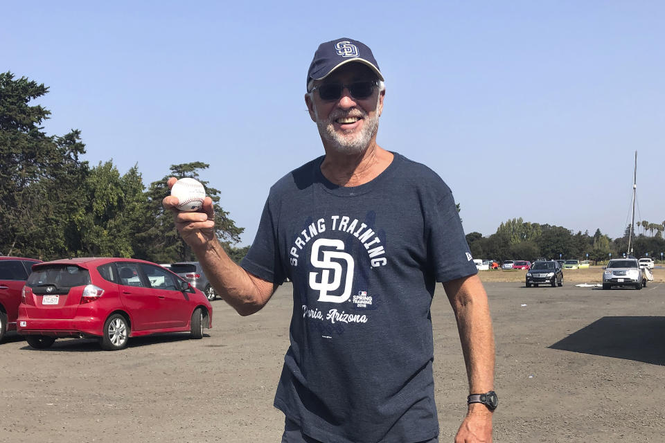 San Diego Padres fan Bob Gans, of La Jolla, Calif., holds his foul ball surprise at Washington Park, Sunday, Sept. 20, 2020, in Alameda, Calif. (AP Photo/Janie McCauley)