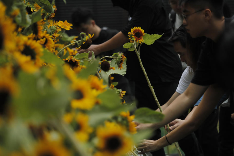 Attendees take part in a public memorial for Marco Leung, the 35-year-old man who fell to his death weeks ago after hanging a protest banner against an extradition bill, in Hong Kong, Thursday, July 11, 2019. The parents of Leung have urged young people to stay alive to continue their struggle. (AP Photo/Kin Cheung)