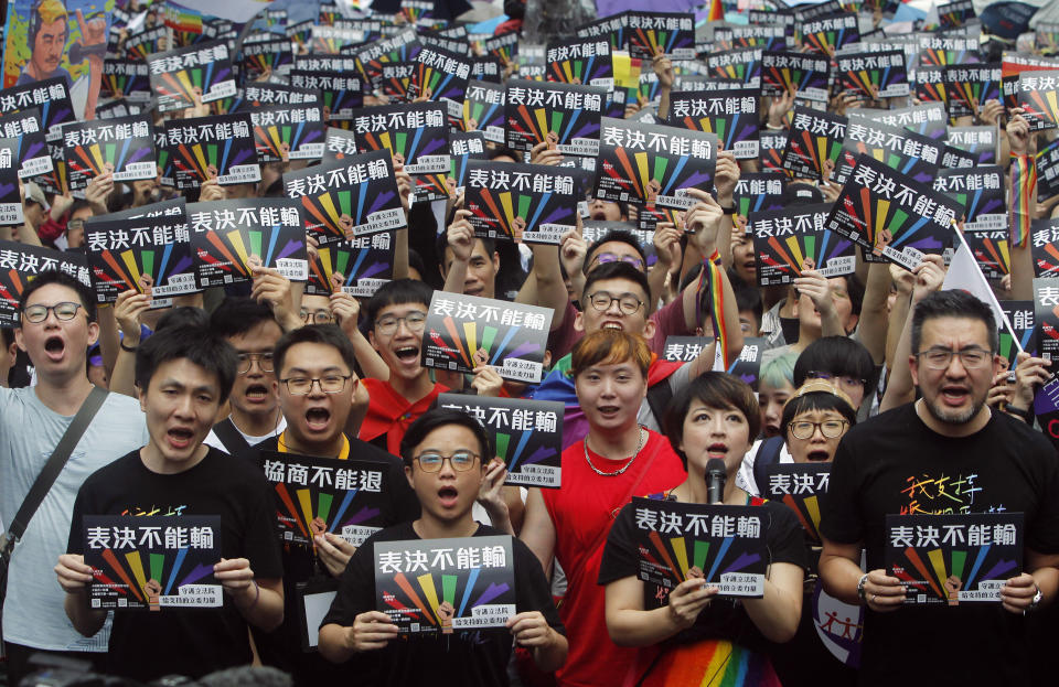 Same-sex marriage supporters gather outside the Legislative Yuan in Taipei, Taiwan, Friday, May 17, 2019. Taiwan's Constitutional Court are scheduled to decide Friday on legalizing same-sex marriage, marking a potential first in Asia. The signs read  ''Vote Can't Be Defeated.'' (AP Photo/Chiang Ying-ying)