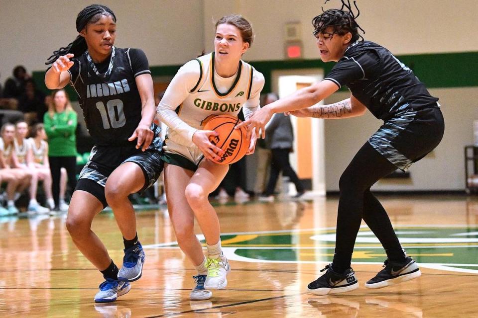 Cardinal Gibbons’ Sarah Maciariello (4) drives between Overhills’ Najiha Allen (4) and Anaiah Mcgee (10) during the first half. Cardinal Gibbons and Overhills met in a NCHSAA 4A second round playoff game in Raleigh, N.C. on March 1, 2024.