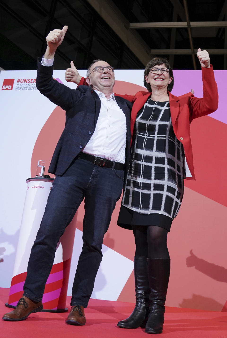 Norbert Walter-Borjans and Saskia Esken wave after the announcement of the result of the vote on the SPD chairmanship in the Willy Brandt House in Berlin, Germany, Saturday, Nov. 30, 2019. Walter-Borjans and Esken have won the vote. The new leadership will be confirmed at the party conference on December 6. (Kay Nietfeld/dpa via AP)