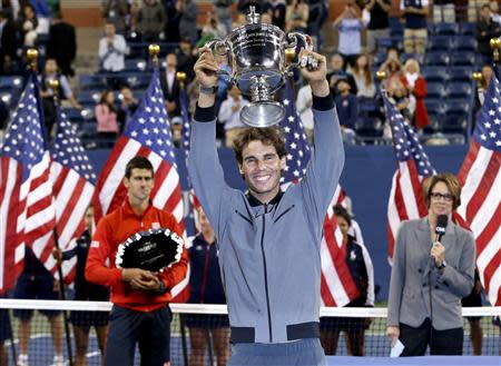 Rafael Nadal of Spain raises his trophy after defeating Novak Djokovic of Serbia (L) in their men's final match at the U.S. Open tennis championships in New York, September 9, 2013. REUTERS/Mike Segar