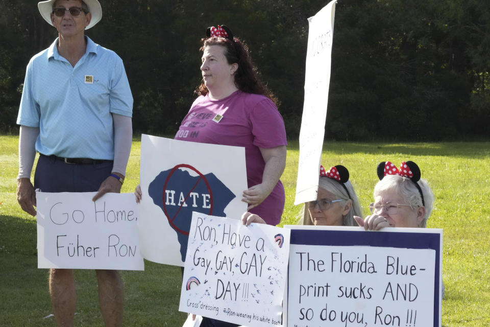 Protesters of Florida Gov. Ron DeSantis hold signs outside the GOP presidential hopeful's event in Bluffton, S.C., on Friday, June 2, 2023. On the heels of his official campaign launch, DeSantis has been visiting the early voting states of Iowa, New Hampshire and South Carolina this week. (AP Photo/Meg Kinnard)
