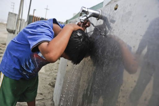 Debajo de la inmensa estructura del cartel, un tanque conserva los 100 litros de agua que diariamente genera el sistema y los pobladores de la zona se acercan, abren un grifo y llenan recipientes y botellas. (AFP | ernesto benavides)