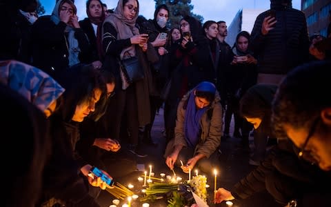 Demonstrators light candles while gathering during a vigil for the victims of the Ukraine International Airlines flight - Credit: &nbsp;Ali Mohammadi/Bloomberg