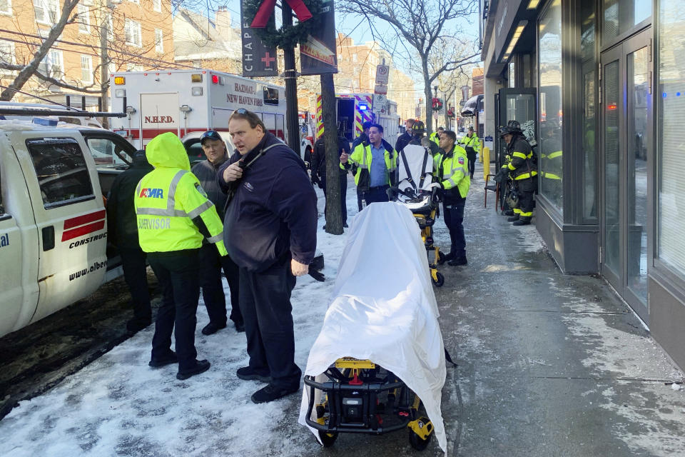 In this photo provided by New Haven CT Emergency Management Director Rick Fontana, ambulance and New Haven CT Fire Department personnel respond to a Yale University-owned building where nine construction workers and five Yale employees who were renovating it were hospitalized for carbon monoxide poisoning, Wednesday, Jan. 17, 2024, in New Haven, CT. One of the workers was found lying unconscious outside of the building, which is a couple of blocks from Yale's New Haven, campus, and was taken to a hospital's hyperbaric chamber in Brooklyn, NY, where he was in critical condition. (Rick Fontana/New Haven Emergency Management via AP)