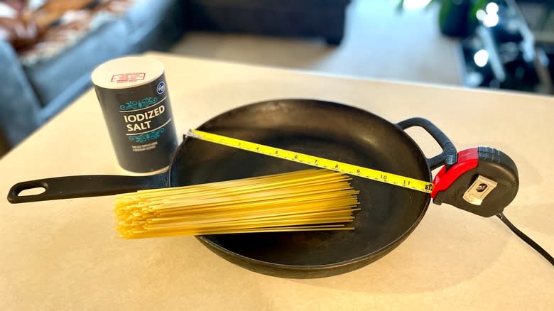 noodles in skillet with measuring tape