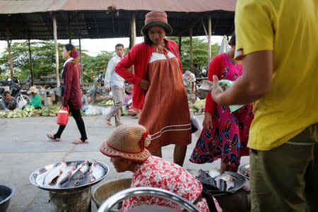 Khen Srey Touch, 27, who is nine months pregnant, buys food at a market outside Complete Honour Footwear Industrial, a footwear factory owned by a Taiwan company, where she works, in Kampong Speu, Cambodia July 4, 2018. Khen Srey Touch works 10 hours a day, six days a week and earns $240 a month. "I am the main breadwinner of the house," she said. REUTERS/Ann Wang