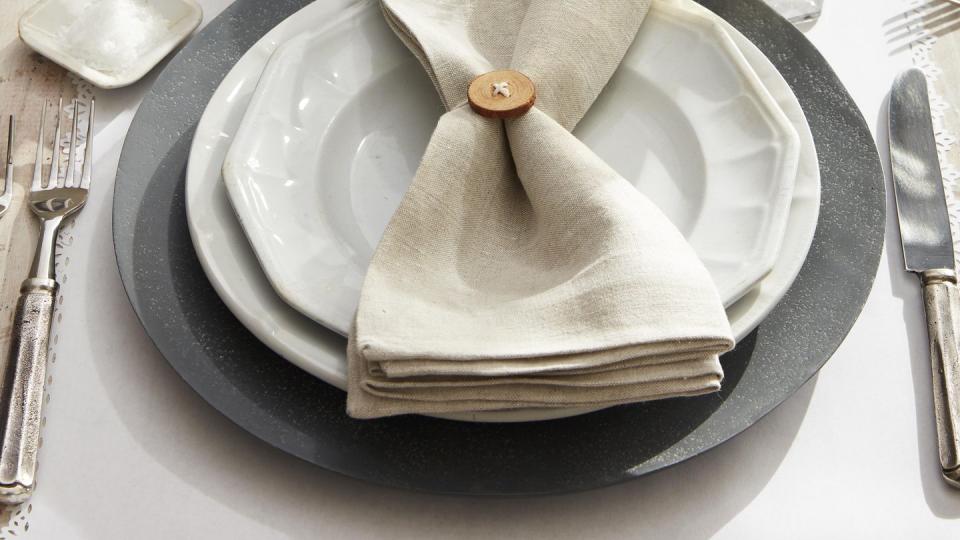 button napkin ring threaded with twine tied on a neutral tone napkin