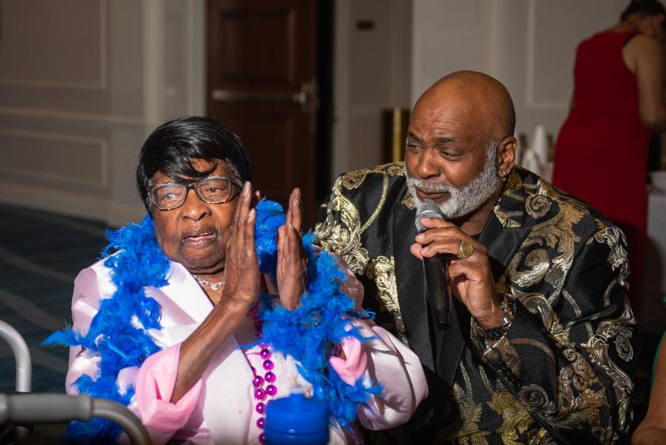 Angelina Dawkins, a 100-year-old Royal Palm Beach resident, claps while being sung to by singer Troy McCray during a 'Young At Heart' prom for seniors held at the the Royal Palm Beach Cultural Center on Friday, May 26, 2023, in Royal Palm Beach, Fla.